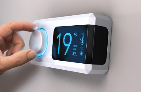 Main réglant un thermostat